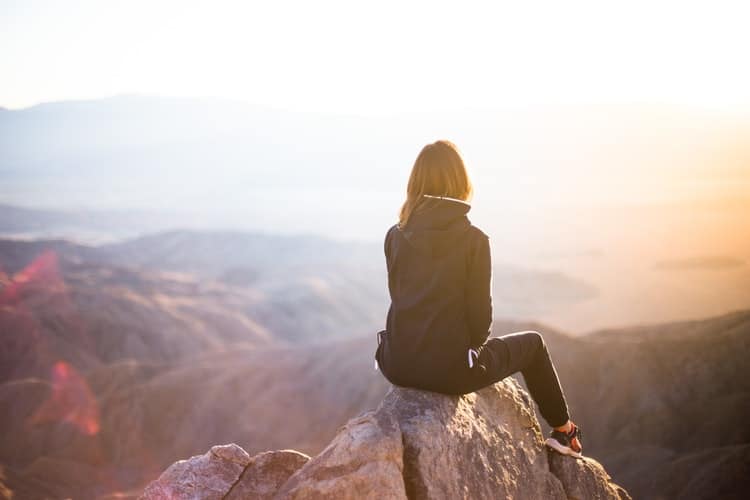 woman calmly sitting in mountains