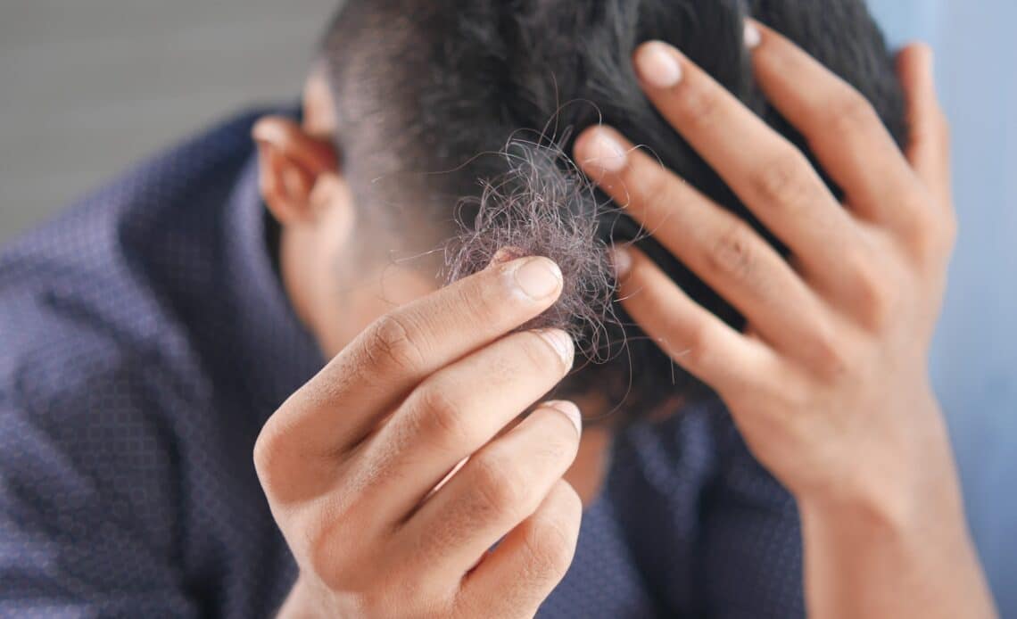 a man is combing his hair with his hands